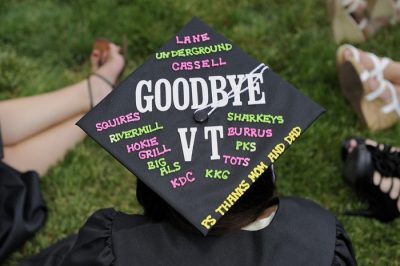 A graduate wears a decorated cap at commencement that says "Goodbye VT"